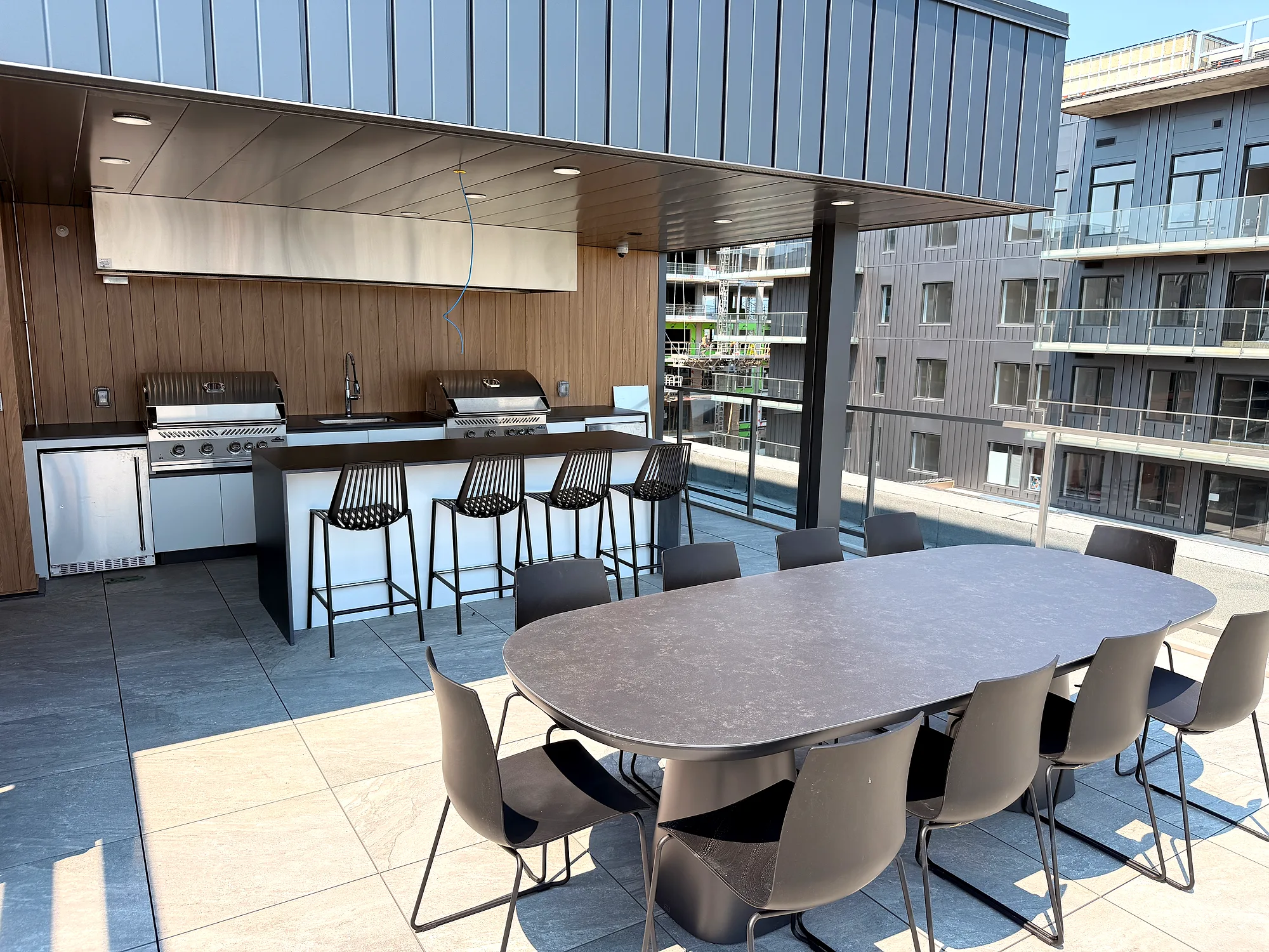 Cuisine extérieure et grande table à manger sur la terrasse commune, projet Place Fleur de Lys à Québec