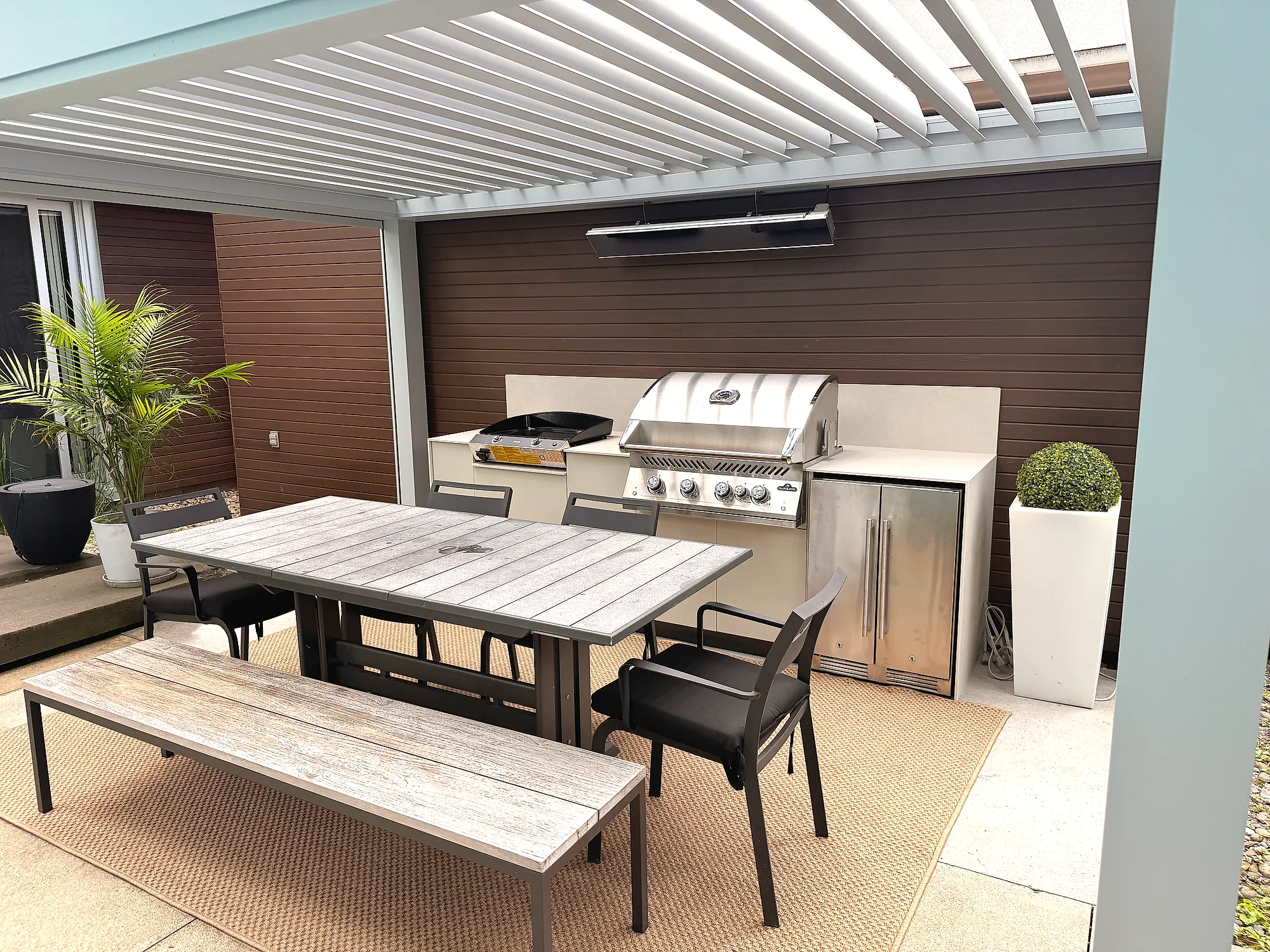 Cuisine extérieure résidentielle sous pergola bioclimatique à Cap-Rouge, avec BBQ Napoléon série 700, plancha et armoires Blanc crème, projet Grenon