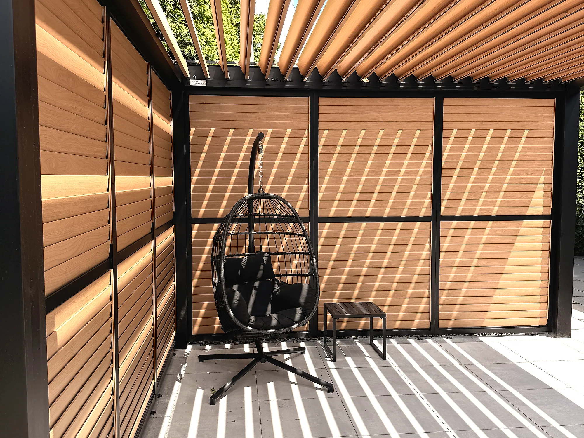 Détail des lames orientables fini bois du toit et des murs d’intimité de la pergola bioclimatique, projet Mercier