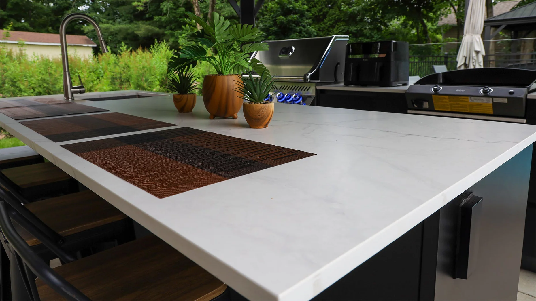 Outdoor kitchen detail with sink, Napoléon BBQ, plancha, and large counter