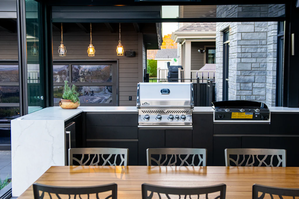 Complete outdoor kitchen in Lévis with Napoléon BBQ, Eno plancha, outdoor refrigerator, and Orastone counters